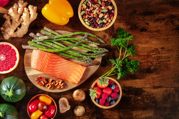 Superfoods, overhead flat lay shot with copy space. Salmon, asparagus, ginger, zucchini, shot from the top on a dark rustic wooden background