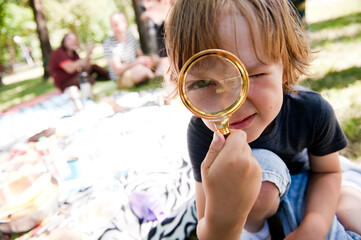 The child explores the world through a magnifying glass.