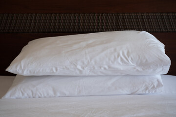 Fototapeta na wymiar Stack of white soft pillows on comfortable bed sheet