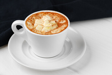 Cup of coffee with whipped cream on white table