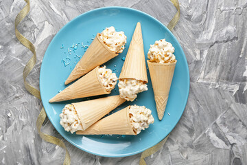 Waffle cones with popcorn balls on grey background