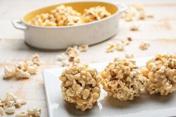 Tray with tasty popcorn balls on wooden background