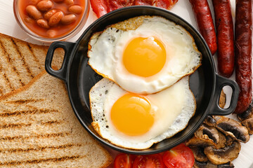 Traditional English breakfast with fried eggs in plate, closeup