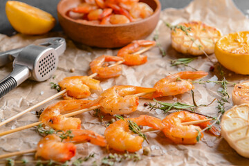 Parchment with tasty shrimps on table, closeup