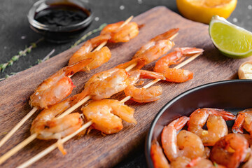 Board with tasty shrimps on table, closeup