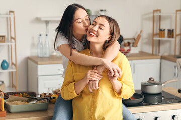 Young lesbian couple in kitchen at home