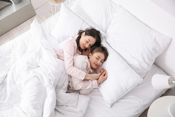 Young lesbian couple sleeping in bed