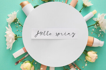 Composition with cosmetics, card and spring flowers on color background