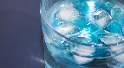 blue ice in a glass of water