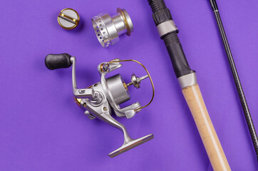 New Disassembled fly fishing reel and fishing rod on blue background.
