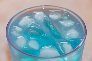 bright blue ice cubes in a glass. Top view