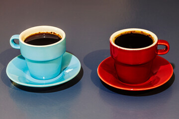 two blue ad red cups of coffee on grey background