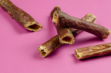 Natural healthy treats for dogs 100% premium quality. Dried beef esophagus, buffalo giblets on a pink background.