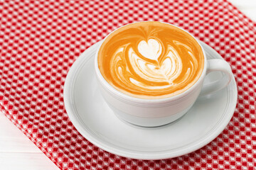 Cup of hot coffee with art on froth