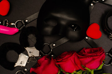 Various sex toys set on a black background. Top view. Spring. Roses. - obrazy, fototapety, plakaty