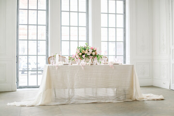 Wedding table luxury decorated with fresh flowers and candles. Pink and white tones and silk