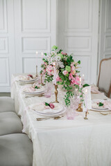 Wedding table luxury decorated with fresh flowers and candles. Pink and white tones and silk