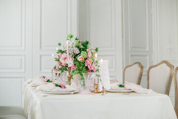 Wedding table luxury decorated with fresh flowers and candles. Pink and white tones and silk