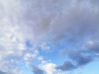 Bright blue sky with fluffy cumulus white clouds. Can be used as a design element, natural background.