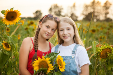 Two happy young girls in a field of sunflowers