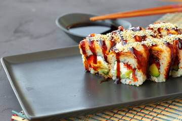 Dragon sushi roll with eel on black ceramic plate