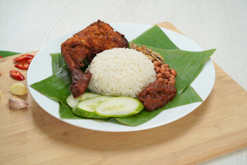 Nasi Lemak dish with chicken drum stick on white wooden verneer