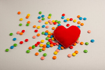Big heart, red heart. Chocolate candies, small multi-colored, on a gray background.
