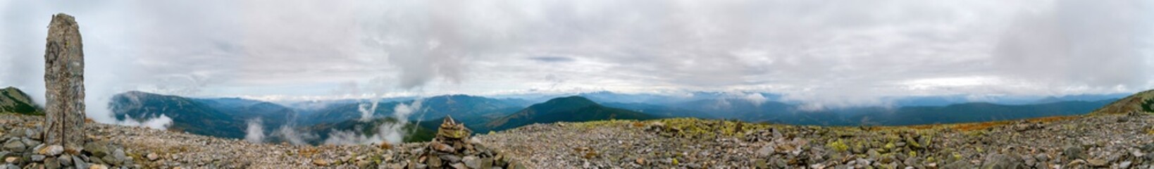 Panorama of mountain peaks. Panorama of rocky placers and storm clouds