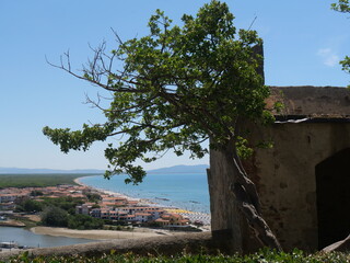 Internal part of the fortifications of Castiglione della Pescaia. In the foreground the surrounding wall and ramparts and in the background the coast lapped by the Tyrrhenian Sea