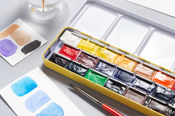 Box of watercolor paints on office desk
