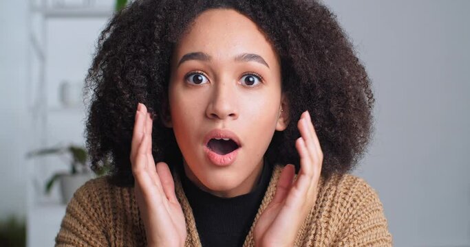 Close-up shocked female face, surprised reaction, afro american curly-haired girl heard amazing unexpected news opens her mouth from stress fear enthusiastic holding head with hands, surprise concept