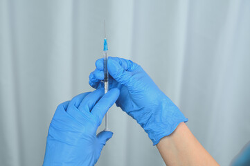 A nurse holds a syringe with a Covid-19 or coronavirus vaccine.  Vaccination concept.