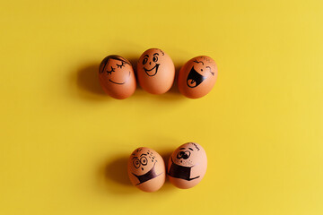 Creative Easter eggs with Corona virus (COVID19) protection concepts. Diverse chicken eggs with doodle faces wearing medical masks on yellow background. Flat lay, top view, mockup, copy space.