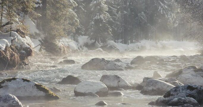 Spring sun melts snow meltdown fog at Alps river water seasons change