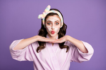 Photo portrait of girl wearing bathrobe looking in mirror on cosmetic effect sending air kiss isolated on vivid violet color background