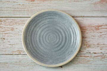 Fototapeta na wymiar empty blue round plate on wood table