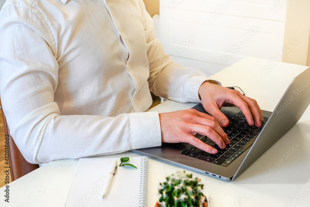 Poster a male programmer works in front of a laptop screen in a bright office or remotely from home. workpl