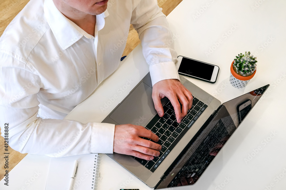 Sticker a male programmer works in front of a laptop screen in a bright office or remotely from home. workpl