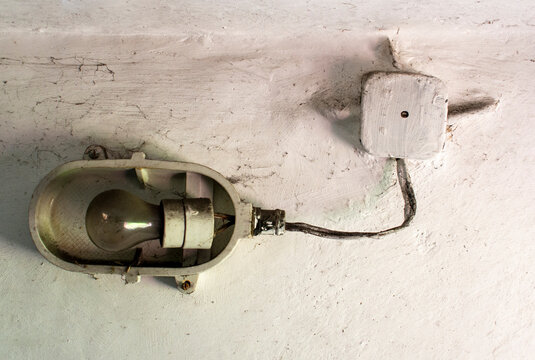 Industrial Old Ceiling Lamp (storage Or Factory Lamp) With Vintage Off Bulb On Dirty White Wall In A Warehouse, Basement Or Attic
