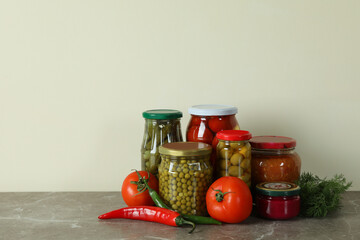 Jars with different pickled food on gray table