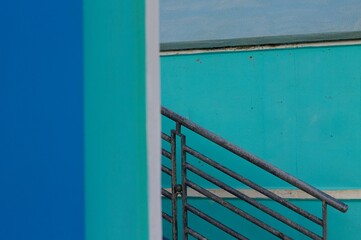 A railing of a staircase between blue beach sheds(Pesaro, Italy, Europe)