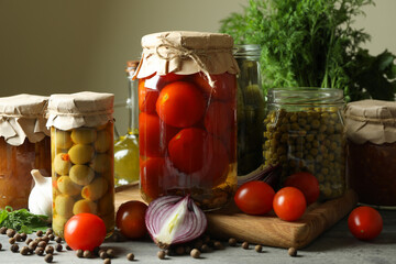 Different pickled food and ingredients on gray wooden table