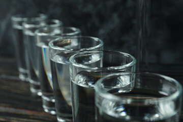 Shots of vodka on wooden background, close up