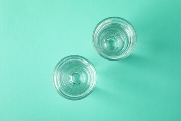 Shots of vodka or tequila on mint background