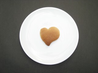 Homemade heart shaped cookie on a white plate