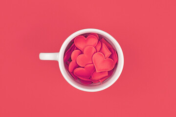 Top view of tea cup filled with red hearts