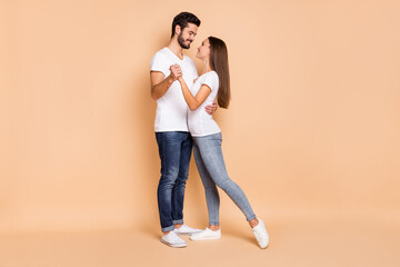Obraz premium Full body profile side photo of young couple happy positive smile hug hold hands dance romantic isolated over beige color background