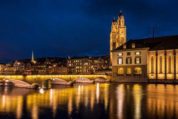 Fototapeta na wymiar Münsterbrücker bridge and Kirche Fraumünster at night in Zürich city in Switzerland