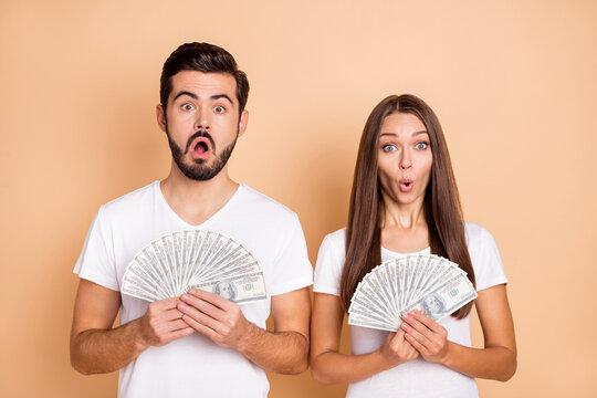 Photo Of Funny Impressed Married Couple Dressed White T-shirts Win Casino Big Amount Money Isolated Beige Color Background