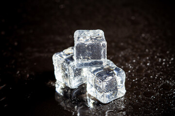 ice cubes reflection on black table background.